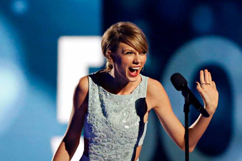 Taylor Swift reacts after receiving her Milestone Award during the 2015 Academy of Country...