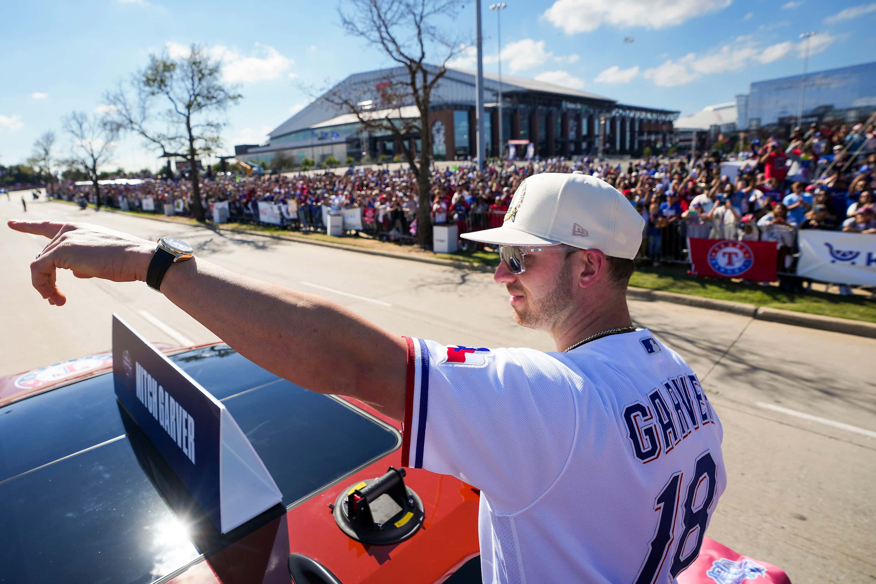 Texas Rangers designated hitter Mitch Garver  waves to fans along the parade route during...