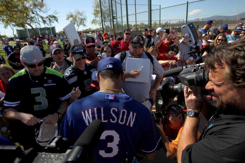 SURPRISE, AZ - MARCH 03: Russell Wilson #3 of the Texas Rangers signs some autographs after...