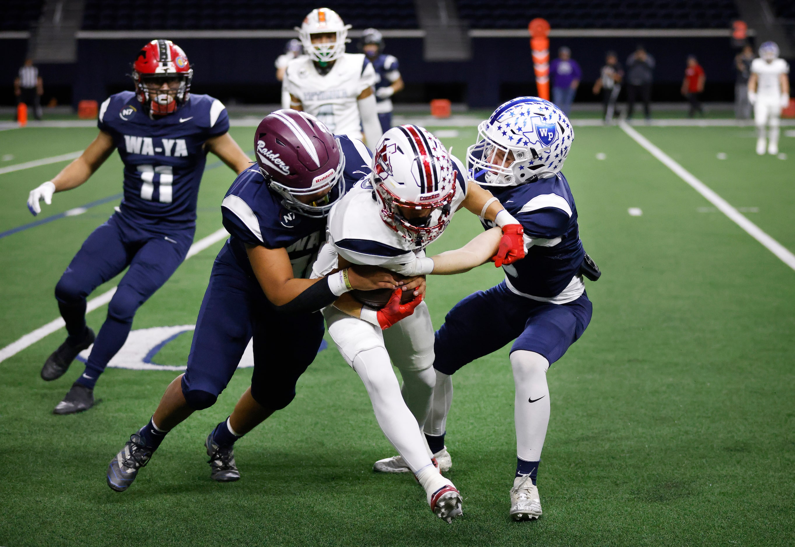 Wa-Ya defensive back Cooper O’Neal (right) of Wills Point High (TX) tackles Ta’ Tanka wide...