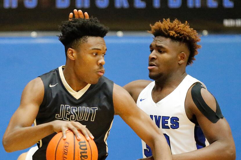 Jesuit forward Julius Marble (34) is defended by Plano West forward Shemar Pearl (30) during...
