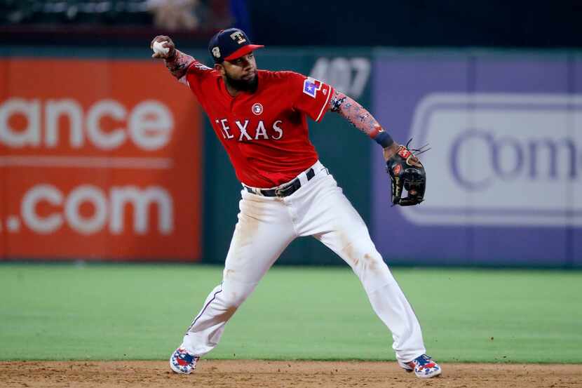 Texas Rangers shortstop Elvis Andrus throws to first after fielding a grounder by Los...