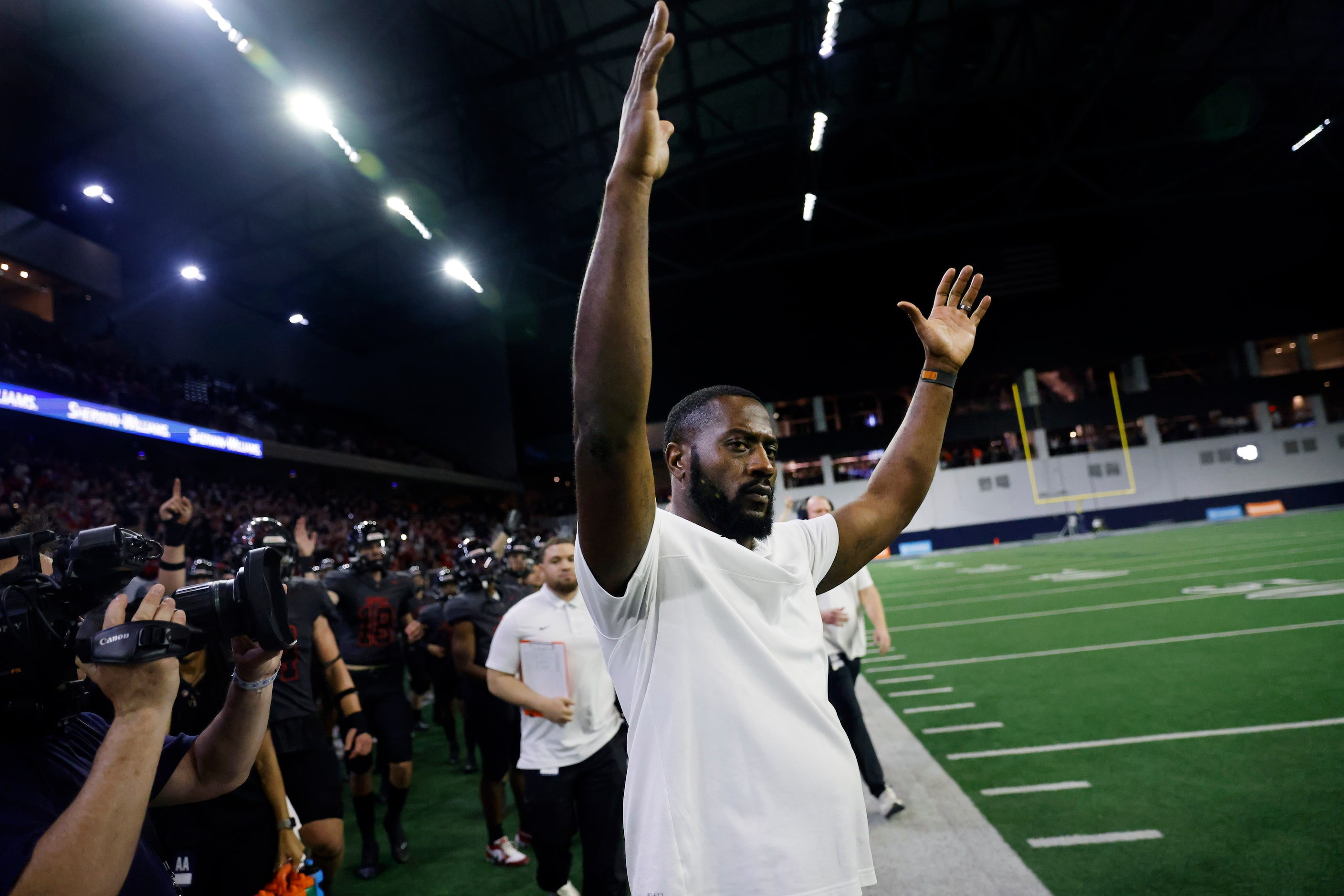 Coppell head coach Antonio Wiley raises his hands in victory as running back O’Marion Mbakwe...