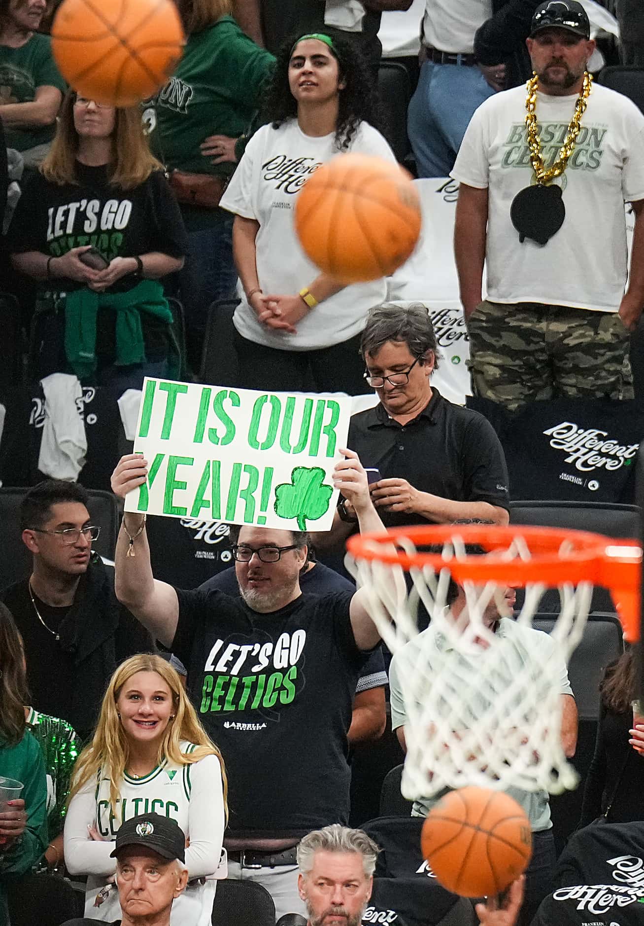 A Boston Celtics fan holds a sign reading “It Is Out Year” as the teams warm up before Game...