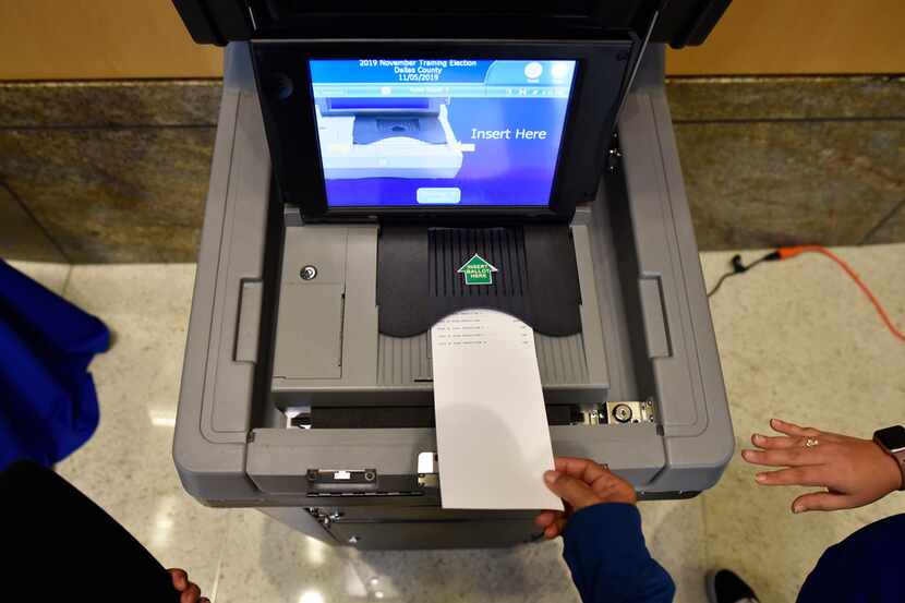 Constancia Shaw, bottom, inserts a training ballot into a scanner that records her votes...