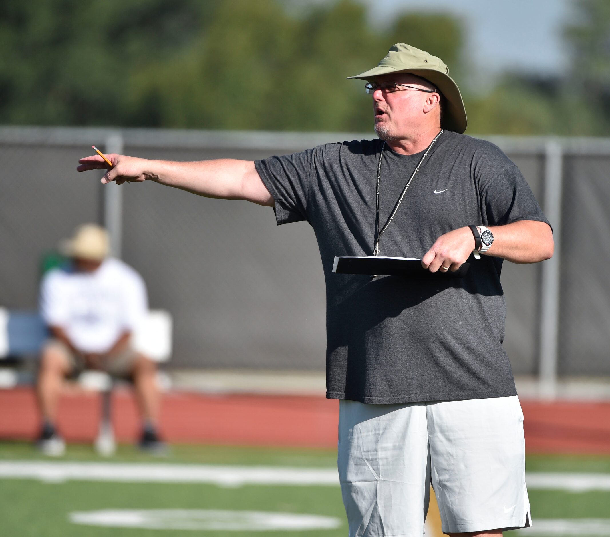 Coach Chris Jensen gives direction to his team during Euless Trinity's first day of football...