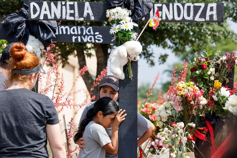 A woman, who did not wish to be identified, comforts a young girl who was friends with Allen...