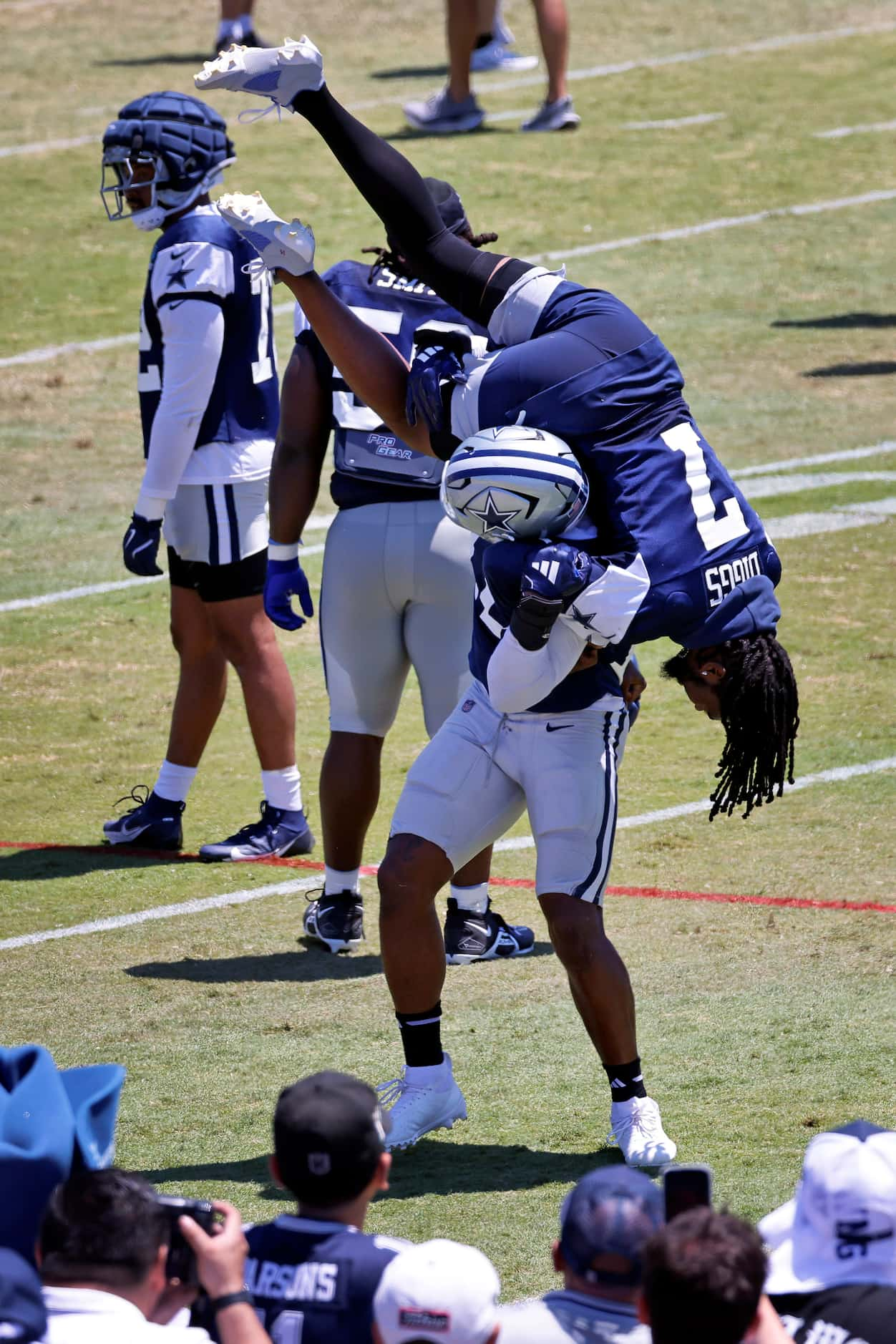 Dallas Cowboys linebacker Micah Parsons (11) drops cornerback Trevon Diggs (7) as the two...