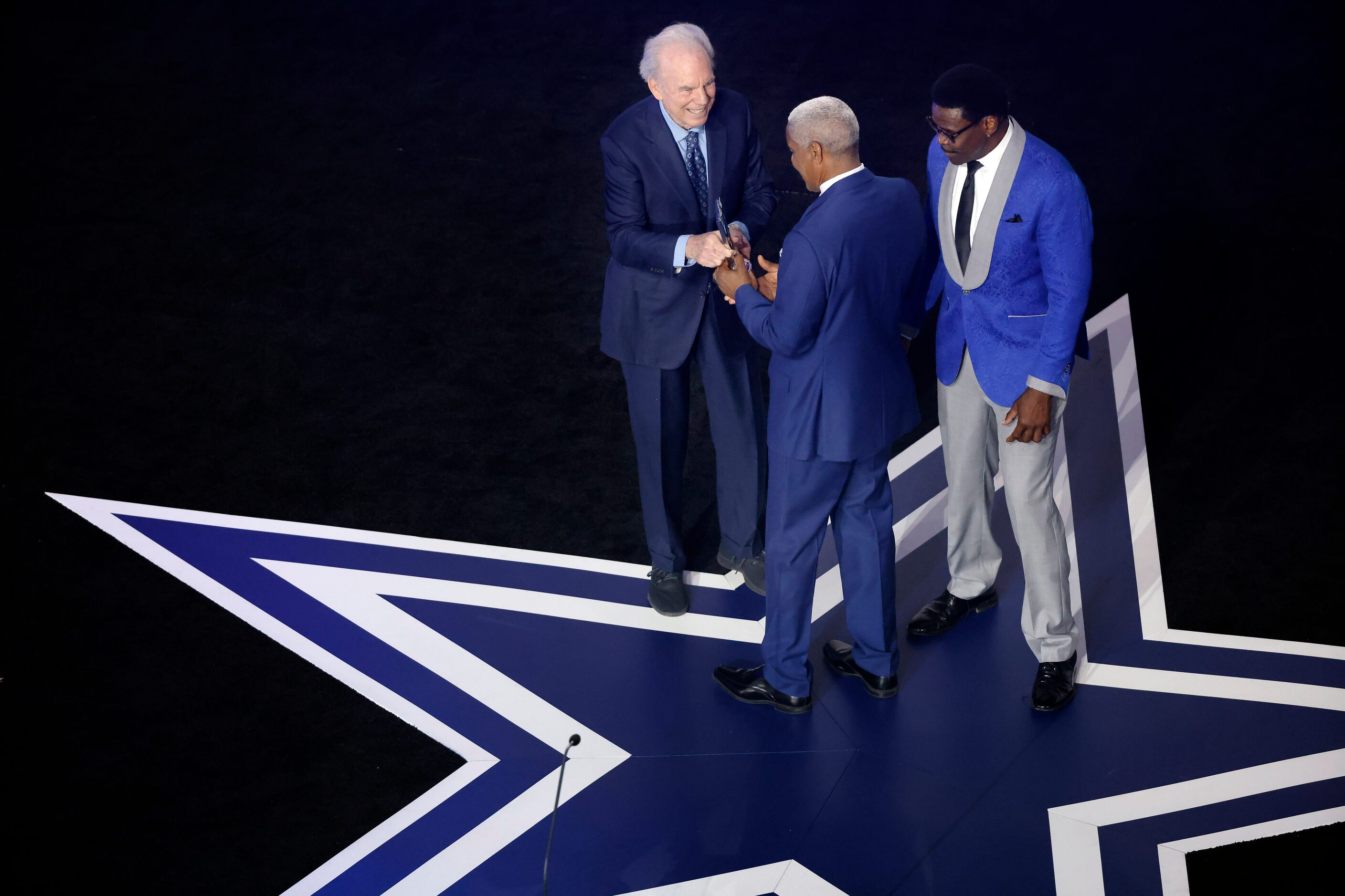 Former Dallas Cowboys quarterback Roger Staubach (left) presents Everson Walls 9center) with...