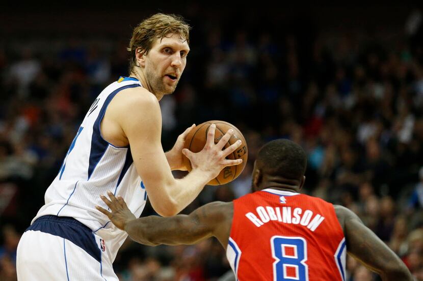 Dallas Mavericks forward Dirk Nowitzki is defended by Los Angeles Clippers guard Nate...