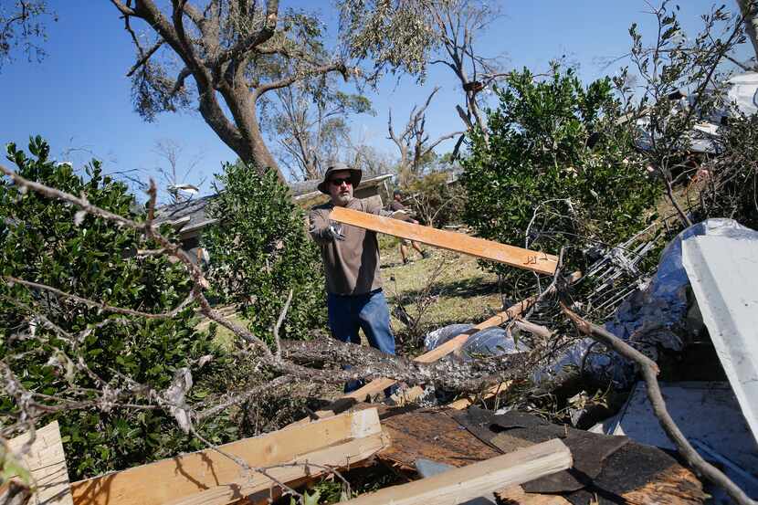 Steve Mauk moves debris to the curbside at his friend's home along North Haven Road in...
