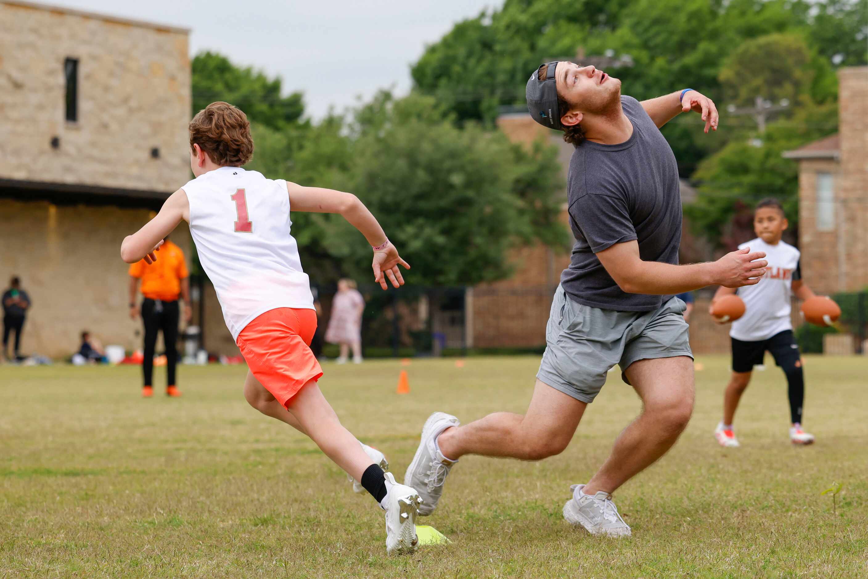 James Jackson (left) dodges SMU QB Preston Stone during a special session of football drills...