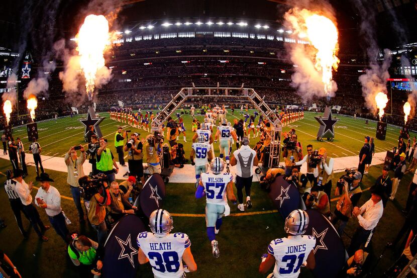 Dallas Cowboys players run onto the field during player introductions before facing the...