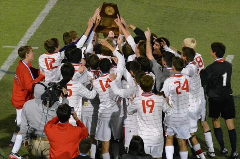 The Coppell High School boys soccer team lifts the 5A UIL State Championship trophy in the...