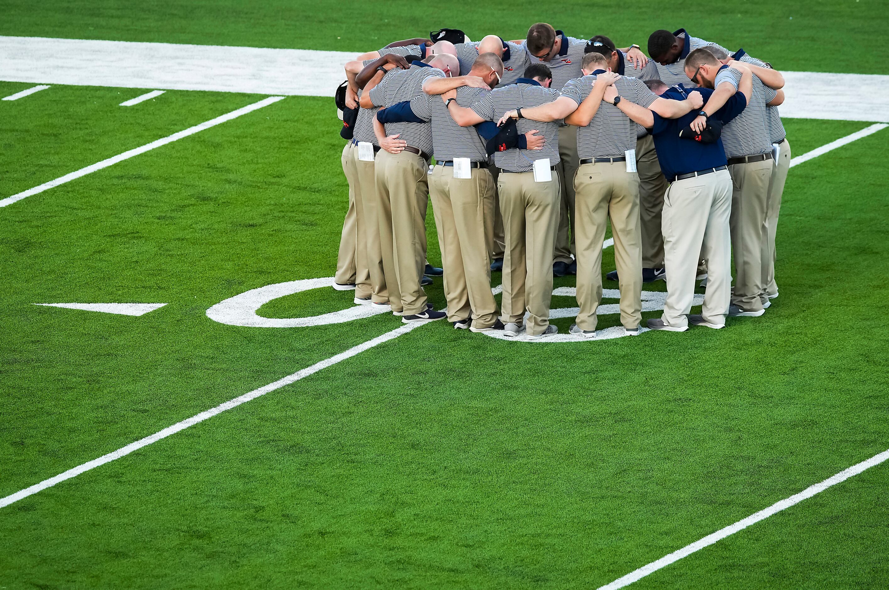 The Frisco Wakeland coaching staff huddles on the field before facing Denton Ryan in a...
