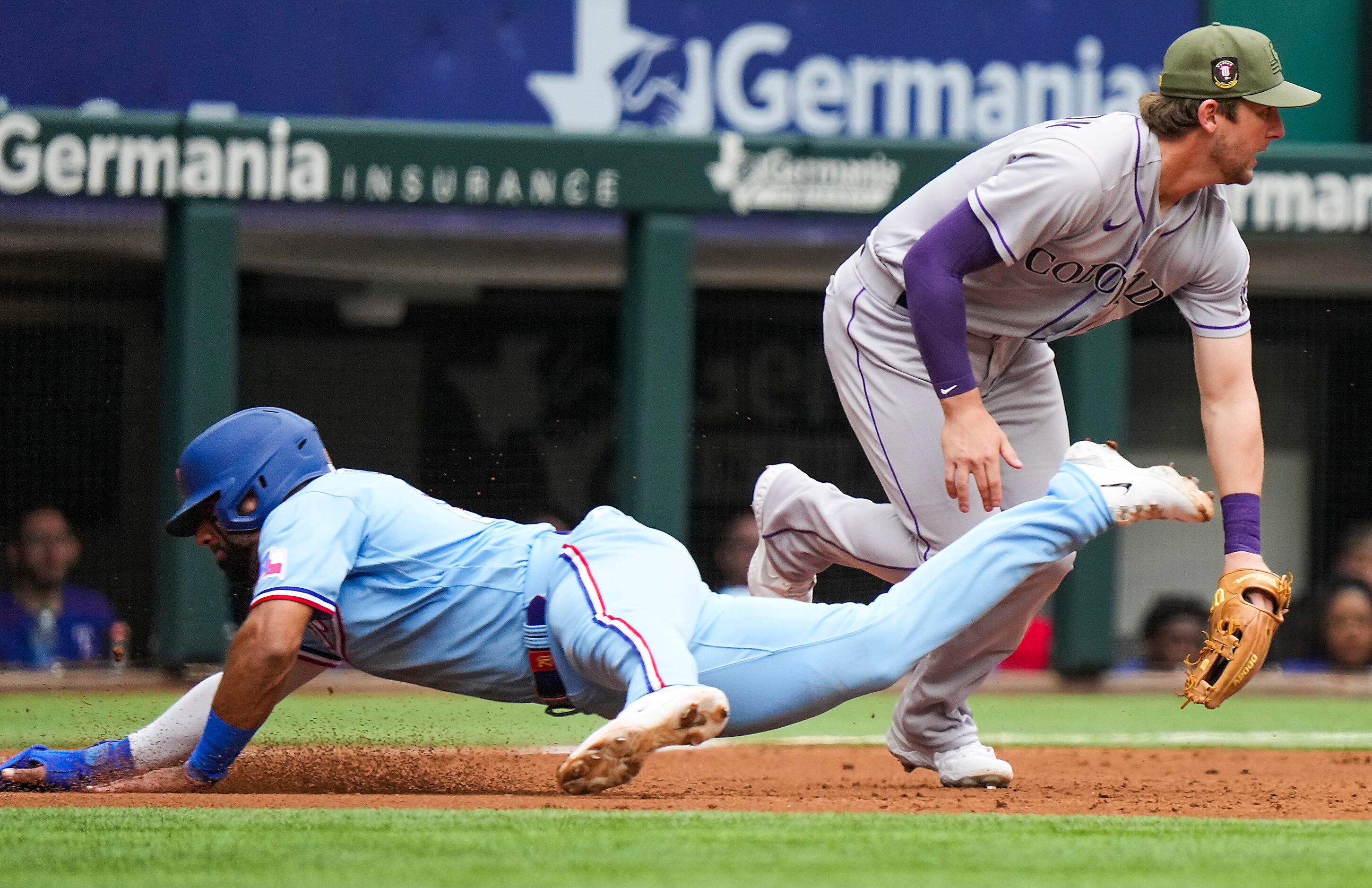 Texas Rangers shortstop Ezequiel Duran (20) dives past Colorado Rockies third baseman Ryan...