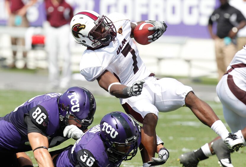 Louisiana Monroe running back Jyruss Edwards (7) is stopped by TCU's Corey Fuller (86) and...