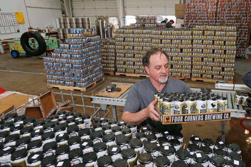 
Dennis Diltz stacks freshly canned beer at Four Corners Brewery in Oak Cliff. A bill...