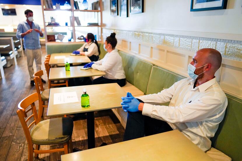 Collin Jackson (right) listens with fellow employees last month at TJ's Seafood restaurant...