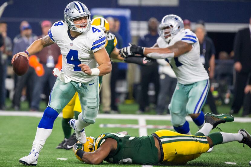Dallas Cowboys quarterback Dak Prescott (4) scrambles away from Green Bay Packers outside...