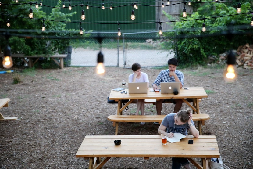 Leneah Brown (front), of Dallas, writes, while Sarah Drexler and Antonio Mondragon (back)...