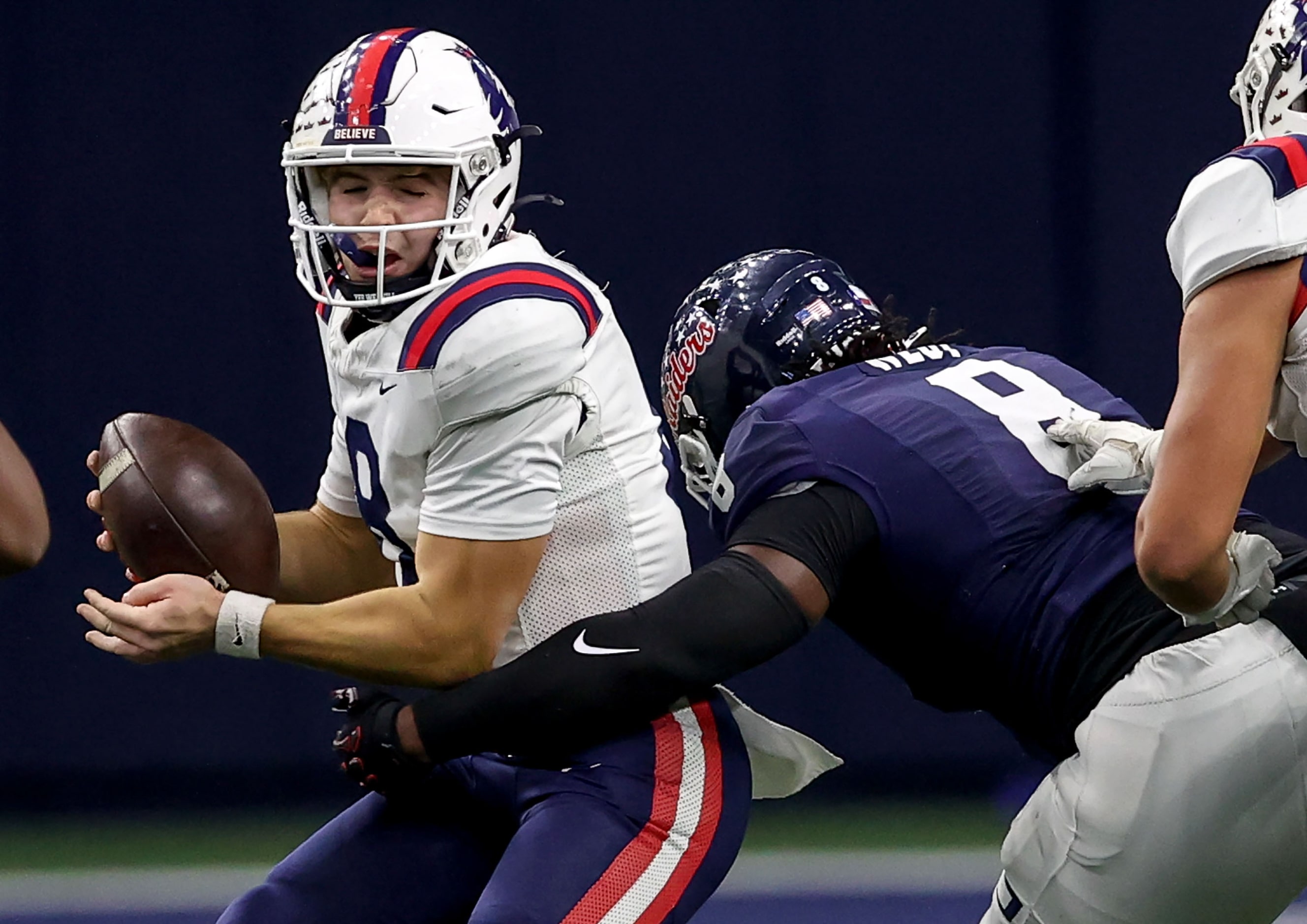 Richland quarterback Drew Kates (left) gets sacked by Denton Ryan defensive lineman Errol...