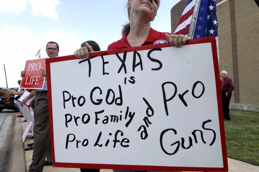 Davonia Leach of Burleson protested state Sen. Wendy Davis outside the venue hosting a rally...