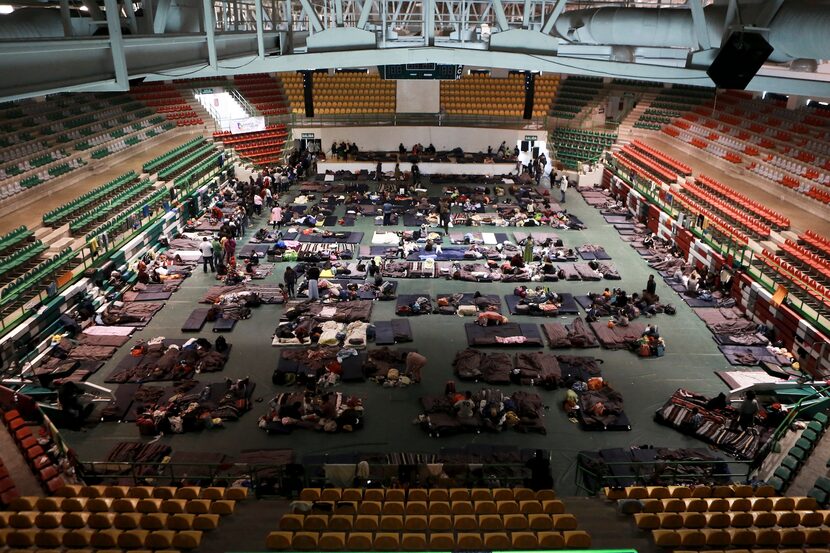 Migrantes de Centroamérica, Africa y el Caribe son atendidos en el Gimnasio del Colegio de...