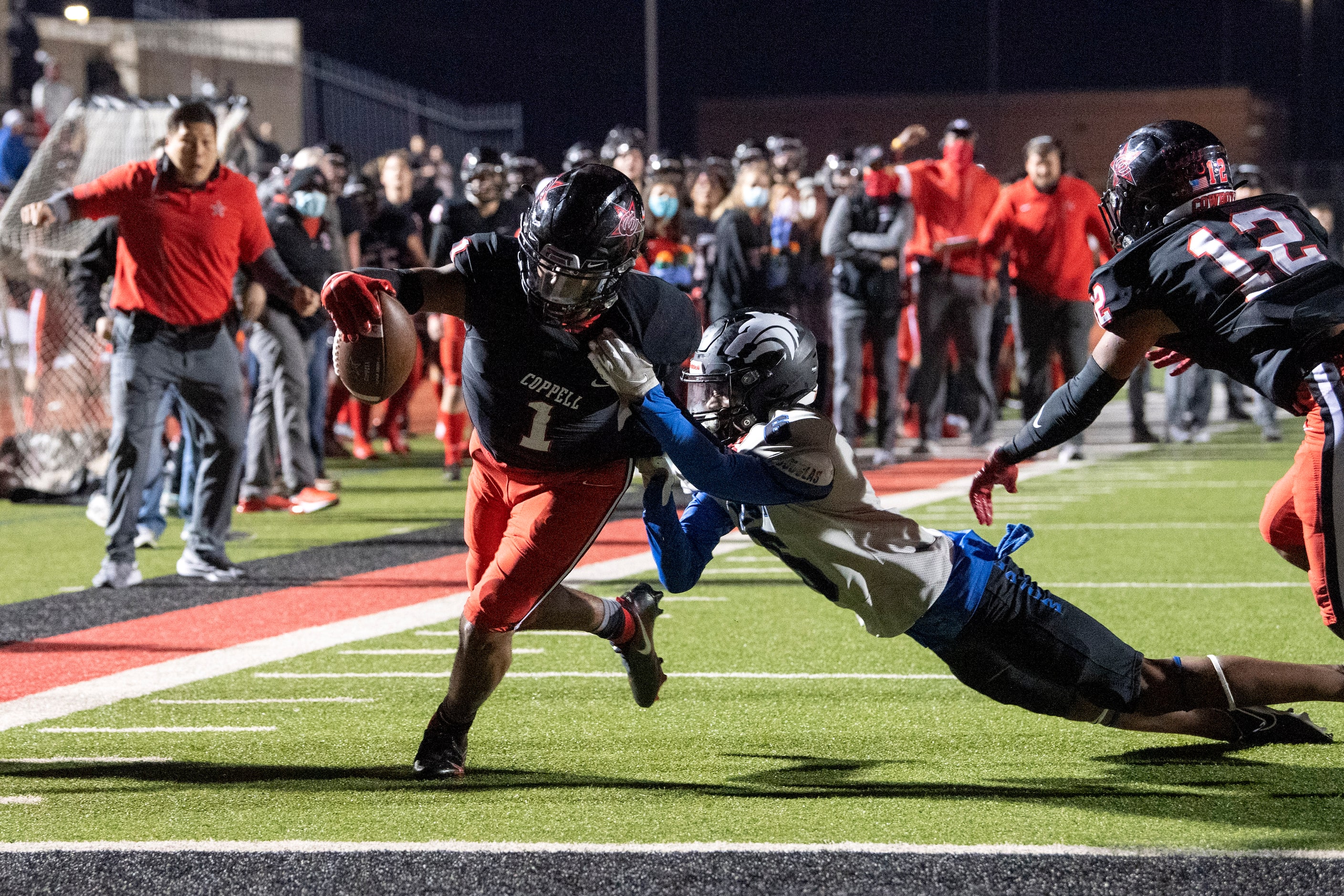 CORRECTION: Coppell senior wide receiver KJ Liggins (1) fights through the tackle of Plano...