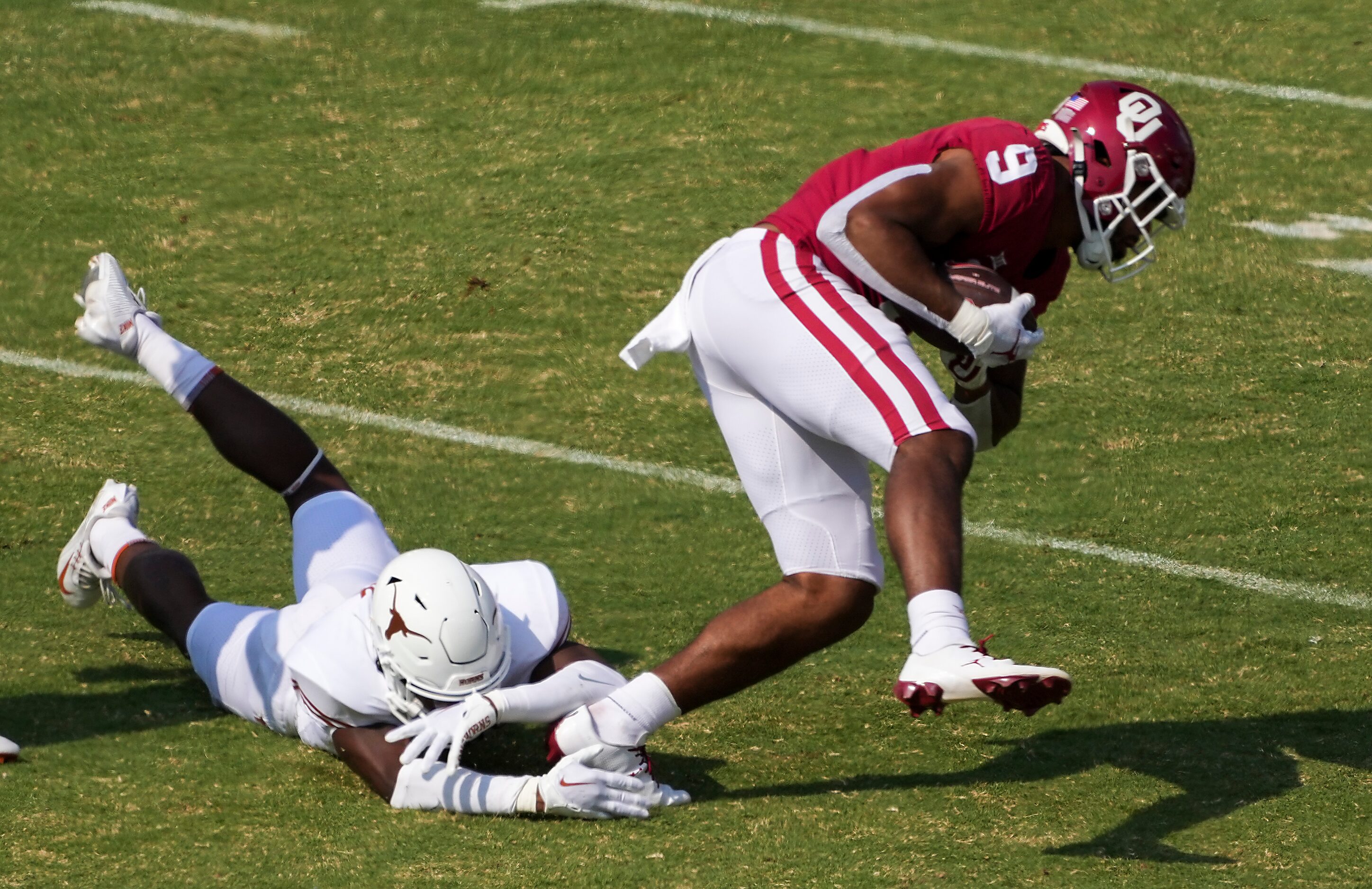 Oklahoma tight end Brayden Willis (9) is tripped up by Texas defensive back Anthony Cook...