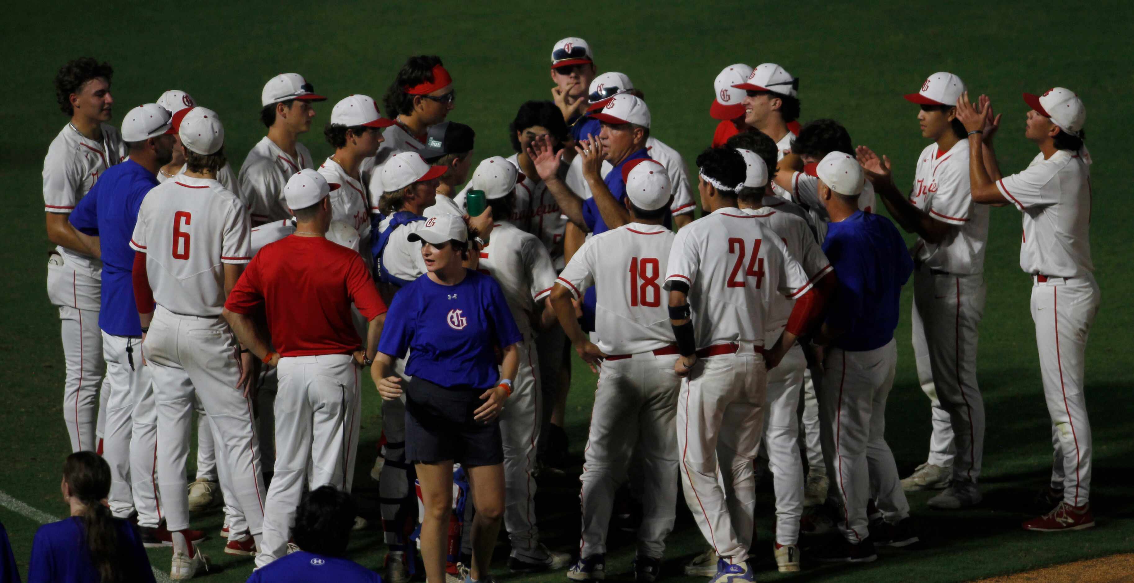 Surrounded by his players, Grapevine head coach Jimmy Webster, center, delivers an upbeat...