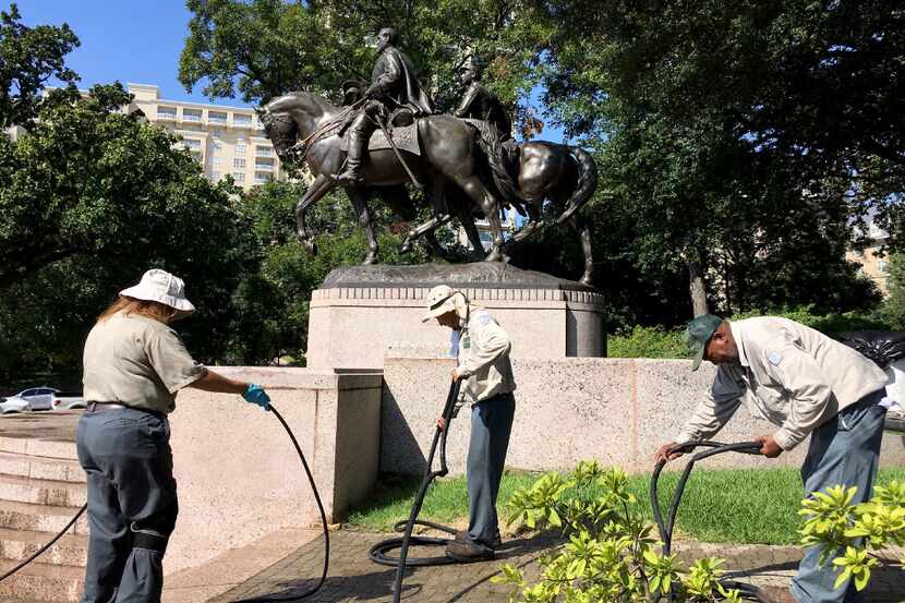 Dallas Parks department workers packed up after removing graffiti from the Robert E. Lee...