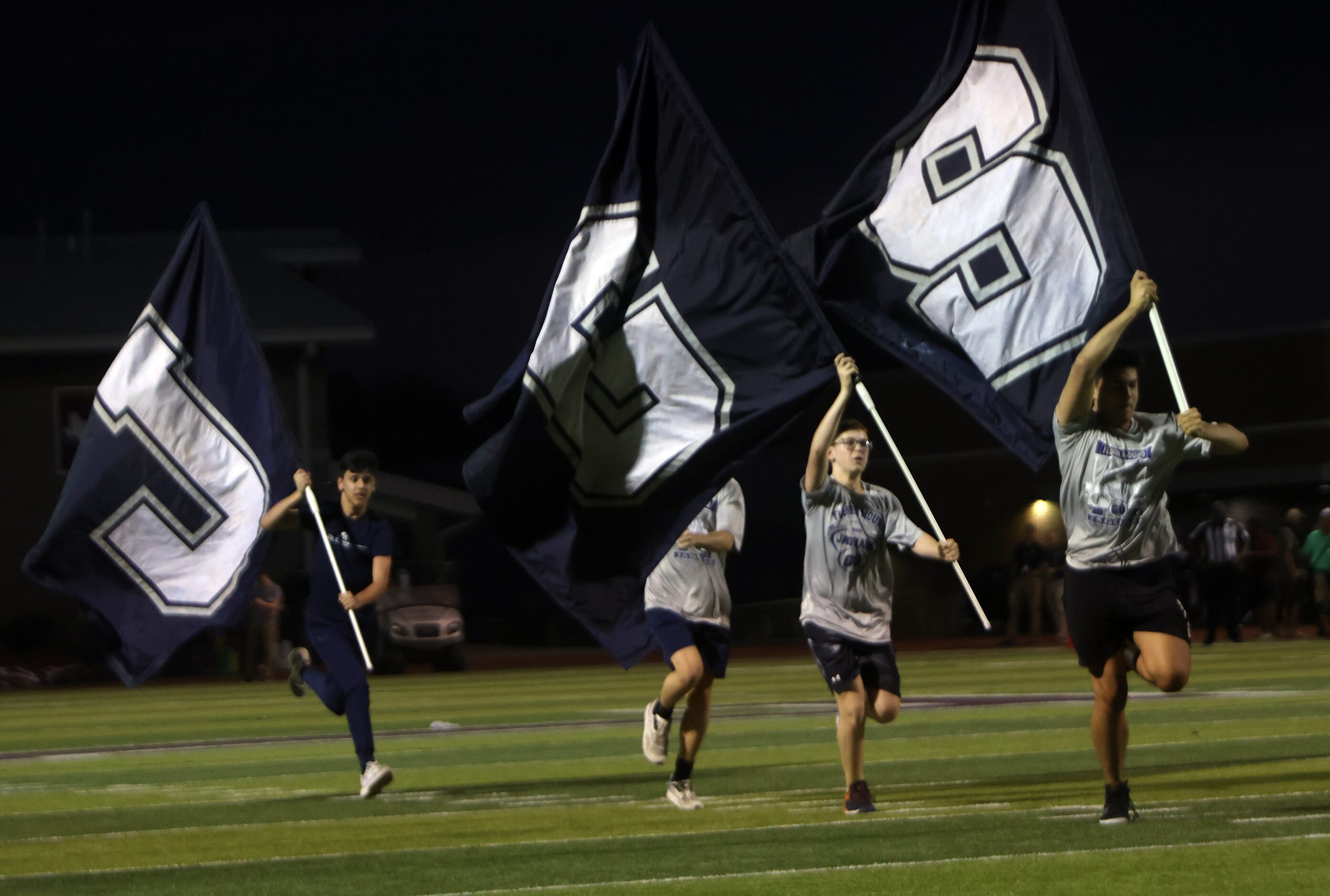 Members of a Flower Mound spirit team race across the field in celebration of Jaguars...