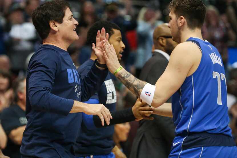 Dallas Mavericks owner  Mark Cuban (left) celebrates a play with forward Luka Doncic during...