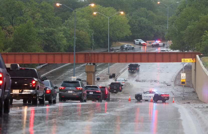 Los autos navegan por un paso subterráneo inundado en North Buckner Boulevard cerca de una...