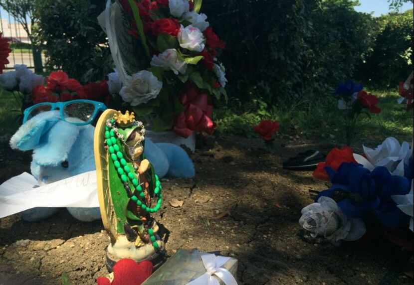  A figurine draped in rosary beads stands at the northwest Dallas grave site. (Liz...