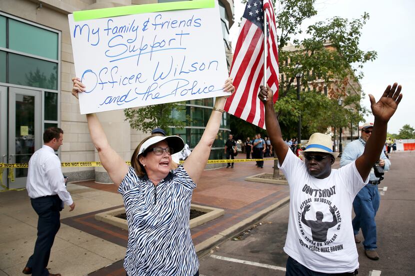 CLAYTON, MO - AUGUST 20:  Patty Canter (L) holds a sign reading, " My Family & Friends...