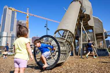 Camryn H., 2, (left) watches as Brooks Petka, 4, comes down the mammoth play structure...