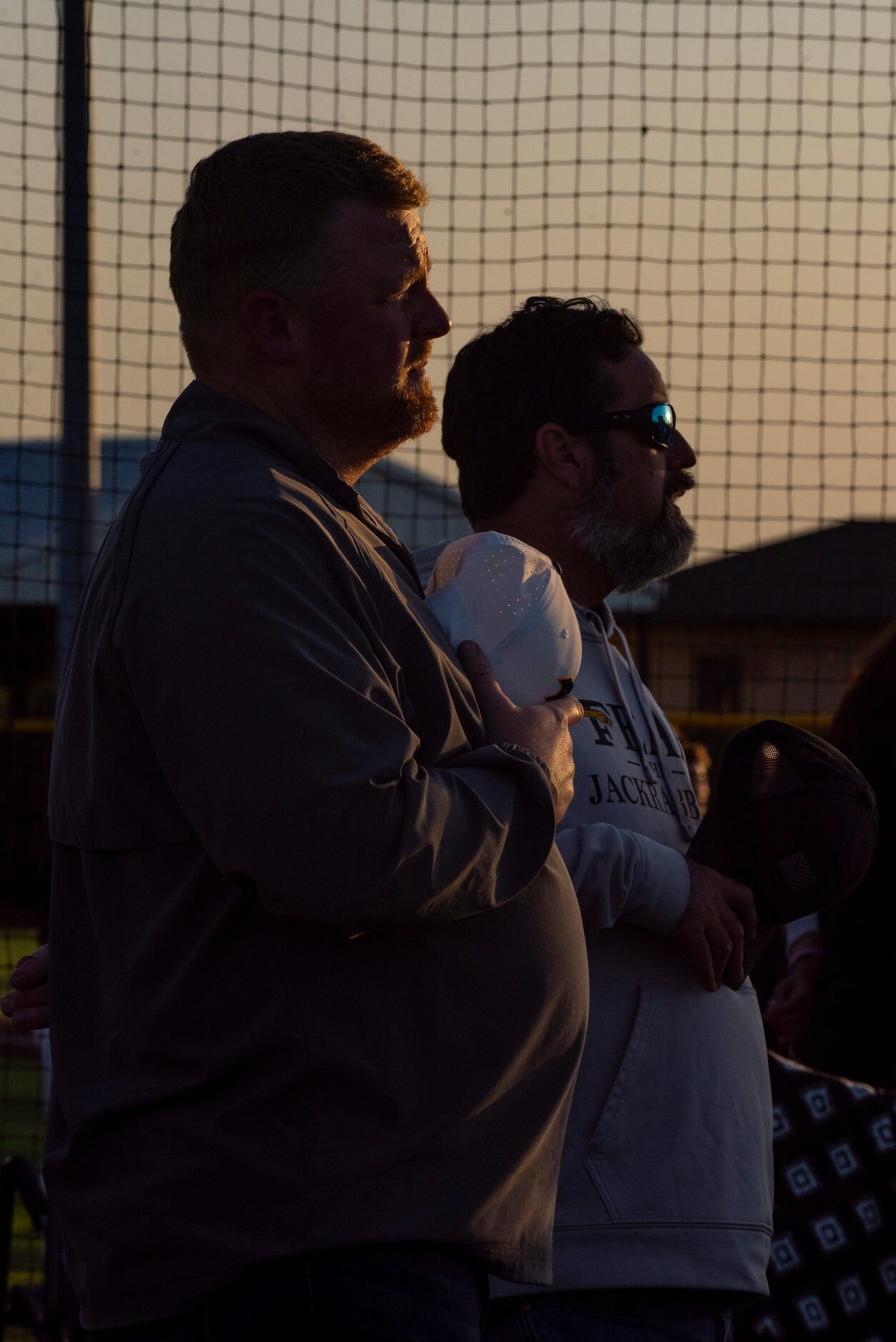 Fans place their hands over their hearts during the national anthem prior to the start of a...