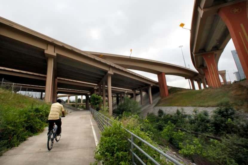 
A cyclist rides north on The Cottonwood Bike Trail under the interchange at North Central...