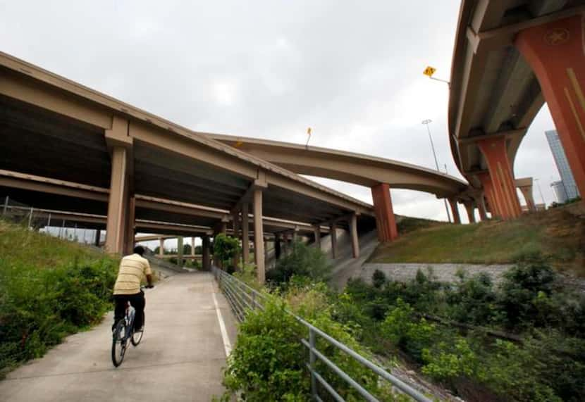 
In a photo taken in 2019, a cyclist rode north on the overgrown Cottonwood Trail, under the...