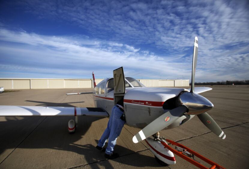 A maintenance man works on a plane at the airport, which serves a mix of single-engine...