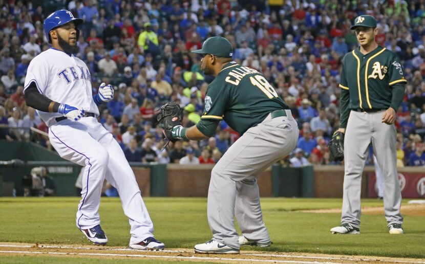 Texas shortstop Elvis Andrus is tagged out on a soft grounder to Oakland first baseman...