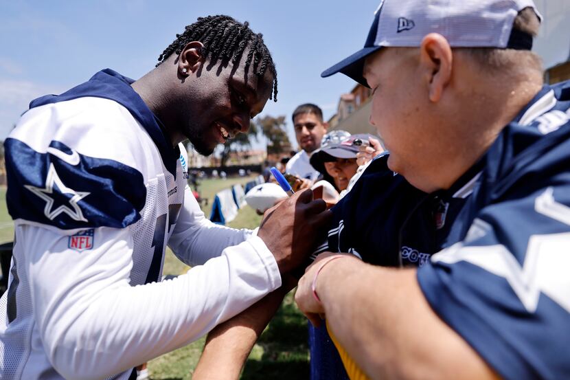 Injured Dallas Cowboys wide receiver Michael Gallup (13) signs autographs for fans following...
