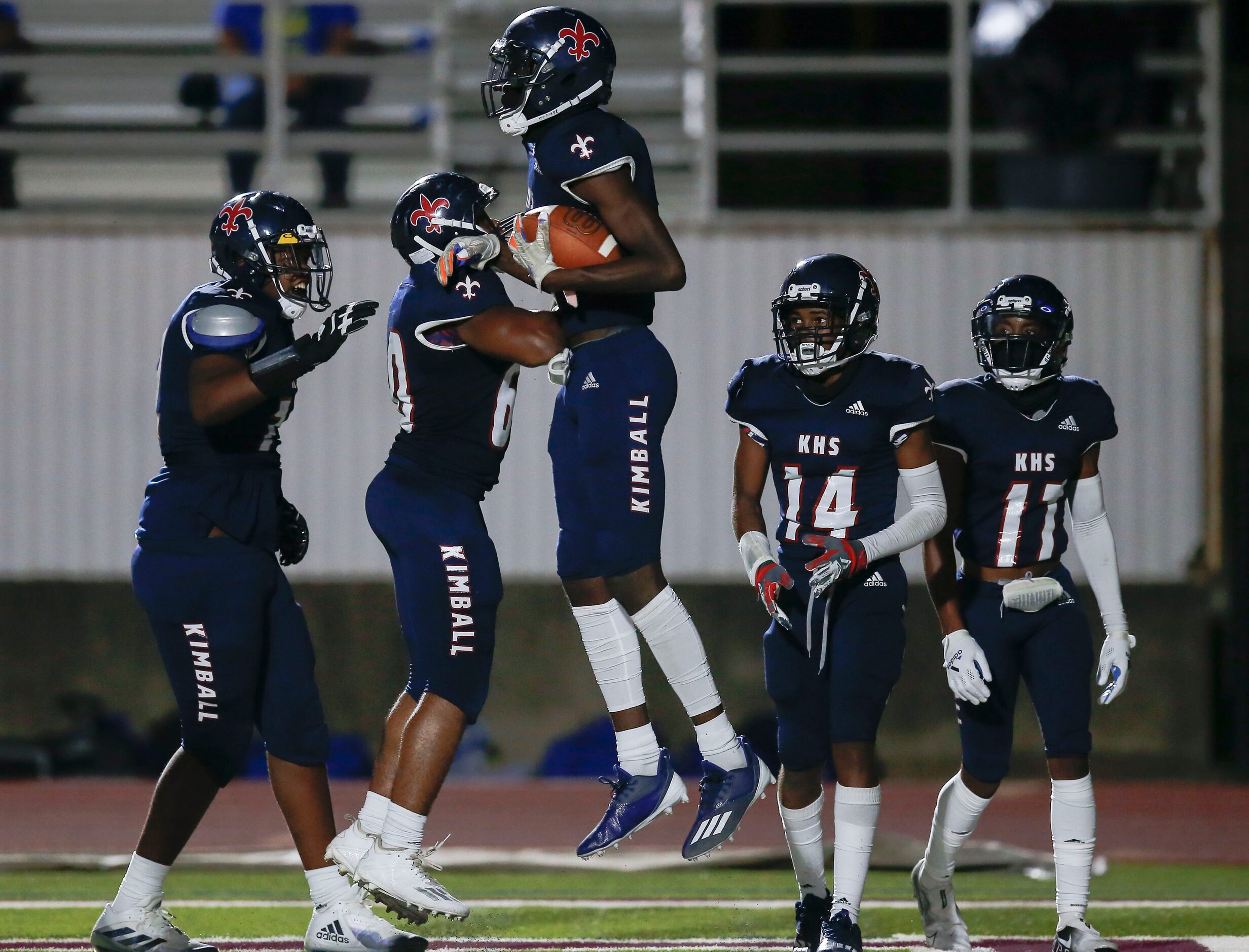 Kimball senior wide receiver Kyron Henderson, center, is congratulated by teammates after...