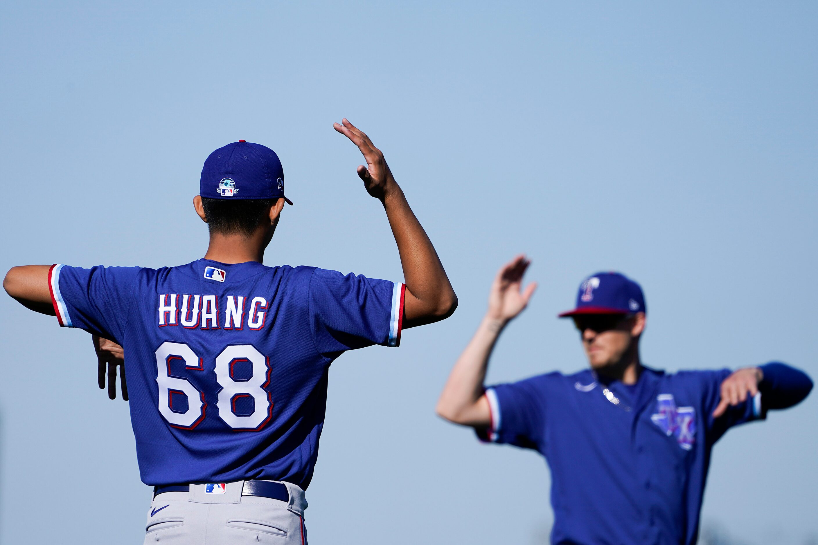 Texas Rangers pitcher Wei-Chieh Huang stretches with teammates during a spring training...