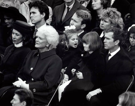 George W. Bush holds his daughter Jenna, 7,  on his lap as she and her cousin Lauren Bush,...