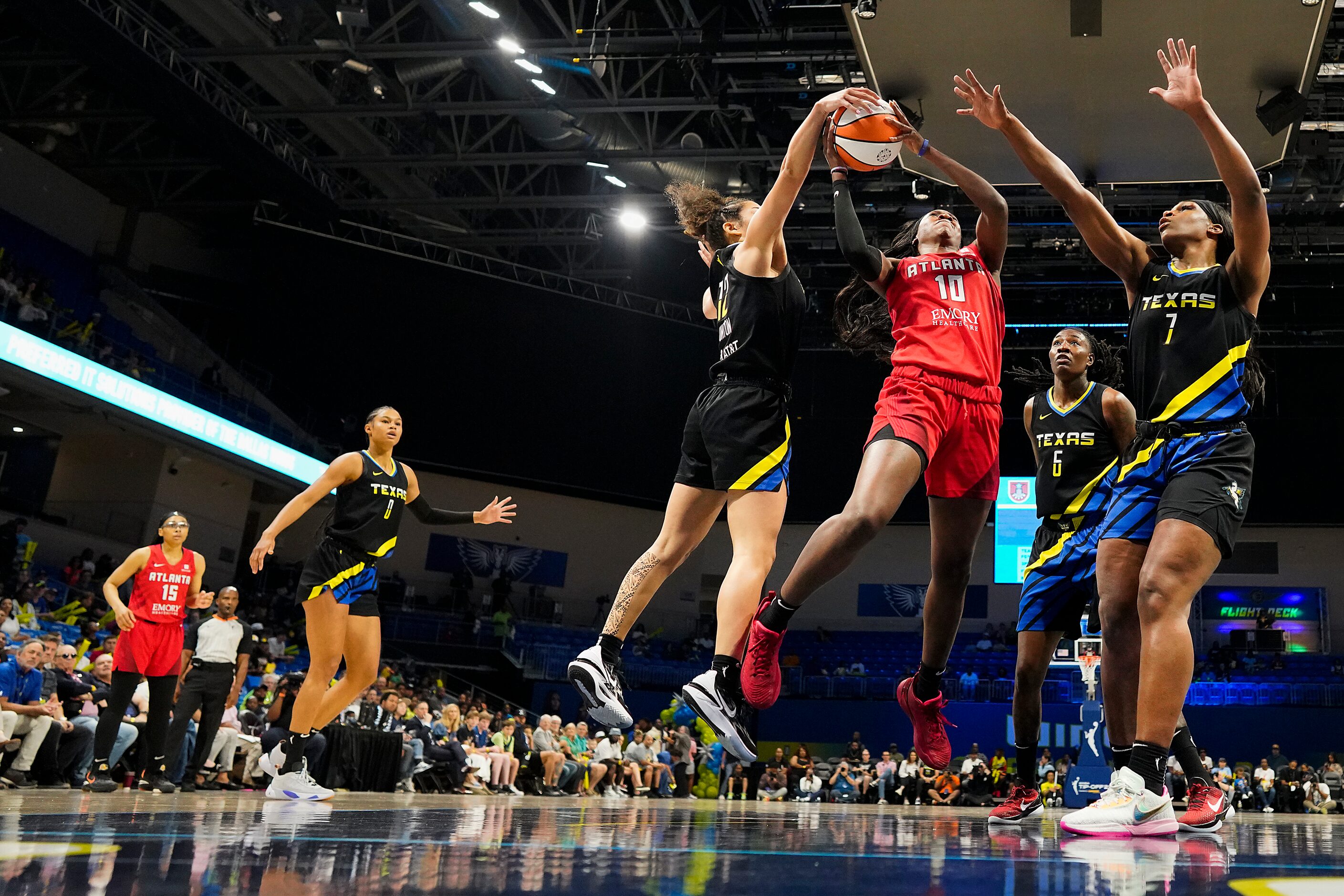 Dallas Wings guard Veronica Burton (12) blocks a shot by Atlanta Dream guard Rhyne Howard...