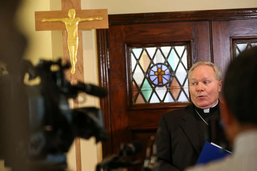 Dallas Bishop Edward J. Burns speaks to members of the media following a police raid on...