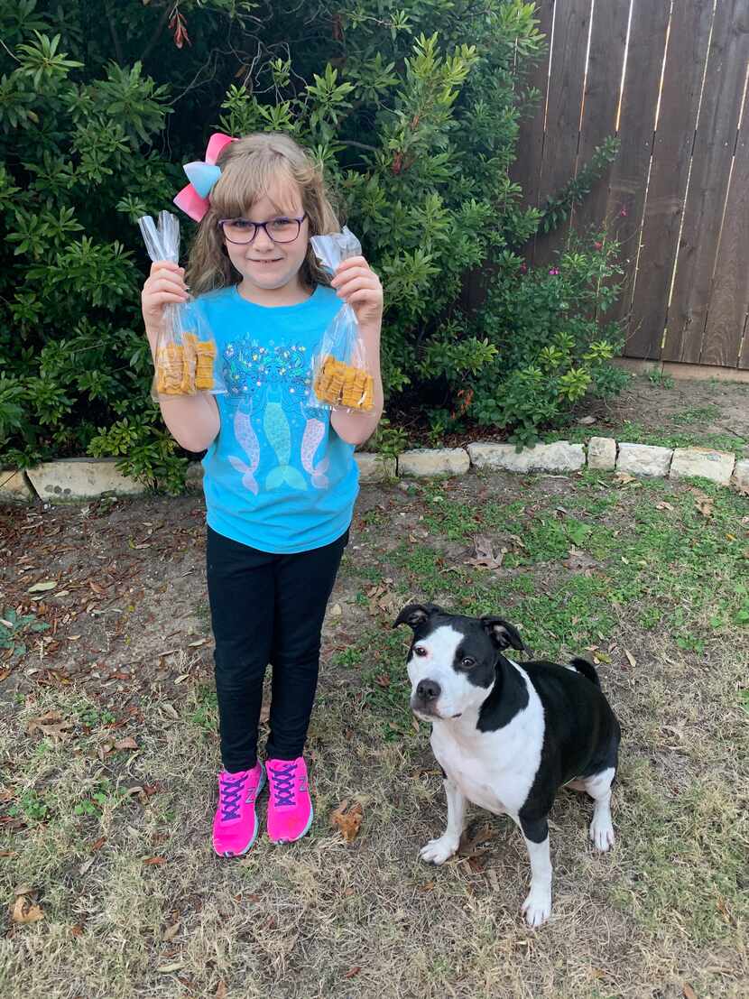 Lily Romito, 8, and her 3-year-old Labrador mix Maggie with fresh homemade dog treats from...